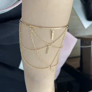 Golden punk style adjustable arm cuff with triple tassel chains and rectangular pendants