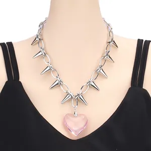 Punk style silver spike necklace featuring a large translucent pink heart pendant