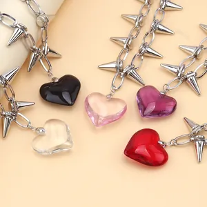 Five punk heart pendant necklaces with silver chains and sharp cone studs on beige base