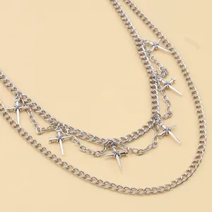 Detail von silbernen mehrlagigen Metallketten mit Punk-Kreuz- und Spike-Anhängern