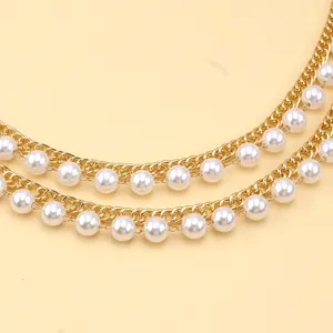 Detail of layered gold metal chain with imitation pearls for vintage body jewelry decor