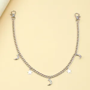 Detail of silver alloy pants chain featuring moon and star pendants with lobster clasps
