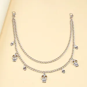 Detail of silver double-layered punk waist chain with metallic skull charms and snap hooks