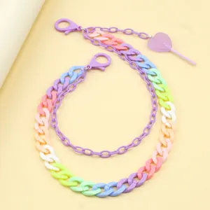 Detail of candy-colored layered resin pants chain with a heart lollipop pendant accessory