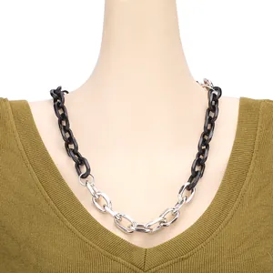 Close-up of black acrylic and silver metal chunky chain necklace on a model