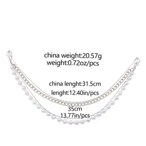 Close-up of double-layer bag strap with silver metal flat chain and white faux pearls