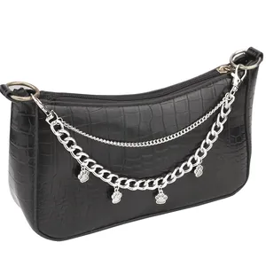 Detail of black crocodile texture shoulder bag with silver chains and paw pendants