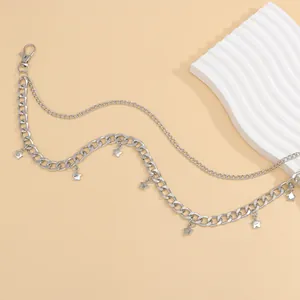Detail of silver layered metal pants chain featuring 3D star charms and lobster clasp