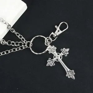 Detail of vintage silver metal cross pendant with iris pattern and rhinestone for pants chain