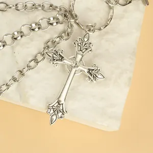 Macro detail of gothic cross pendant with fleur-de-lis edges and inlaid rhinestone