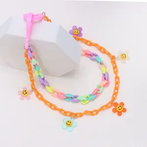 Detail of colorful acrylic chain with smiley flower pendants and pink plastic hook