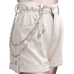 Punk style beige high waist denim shorts with layered silver skull chains on the side
