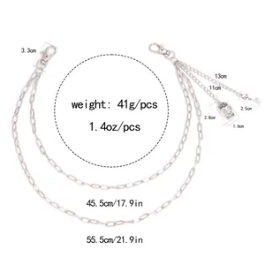 Detail showing skull and key charms on a layered silver metal pants chain with measurements