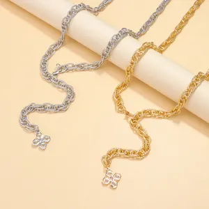 Close-up of chunky gold and silver chain belts with sparkling four-leaf clover pendants