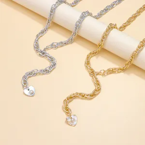 Detail of gold and silver chunky chain waist belts with pearl heart pendants and textures