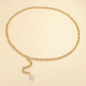 Detailed shot of gold metal waist chain featuring sparkling four-leaf flower pendant