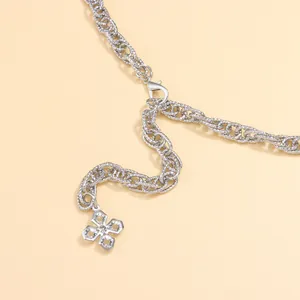 Detail of silver twisted chain belt with crystal-studded floral charm and lobster clasp