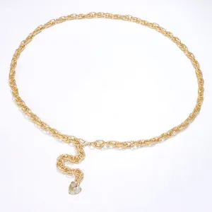 Detailed macro of golden metal waist chain featuring woven rings and heart charm pendant