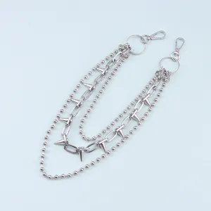 Dettaglio della catena punk argento multistrato con borchie metalliche e chiusure a moschettone