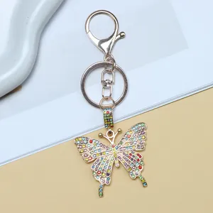 Exquisite gold butterfly keychain with colorful rhinestones on light blue background