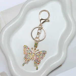 Macro view of crystal encrusted butterfly keychain with colorful rhinestones on gold base