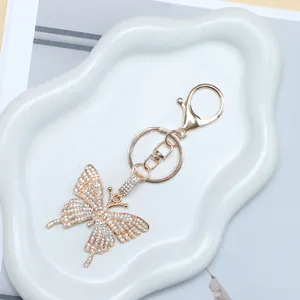 Sparkling butterfly keychain with white rhinestones on golden alloy with lobster clasp