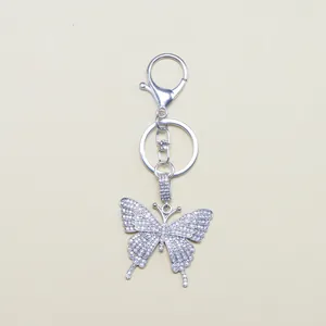 Macro detail of silver butterfly keychain with sparkling crystal rhinestones inlay