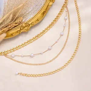 Detailansicht der mehrlagigen goldenen Körperkette mit Kunstperlen und Metallgliedern