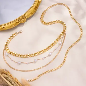 Detail einer mehrlagigen goldenen Taillenkette mit Panzerketten und eleganten Perlen