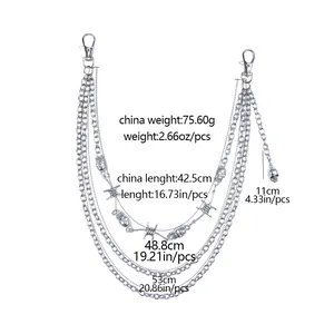 Detail van zilveren gelaagde broekketting met doodskop en prikkeldraad versieringen