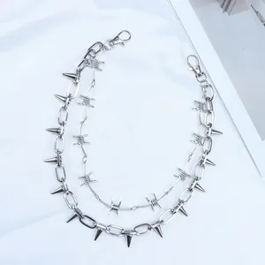 Detail of silver punk pant chain featuring metal spikes and barbed wire link design