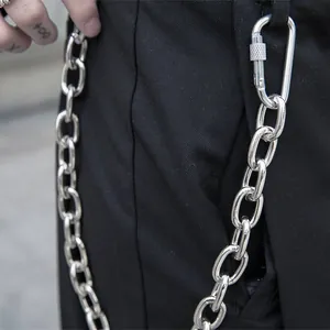 Detailaufnahme einer silbernen groben Gliederkette mit Schraubkarabiner an schwarzer Hose