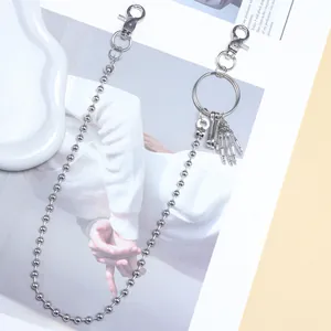 Détail de la chaîne à billes argentée avec pendentif main de squelette gothique