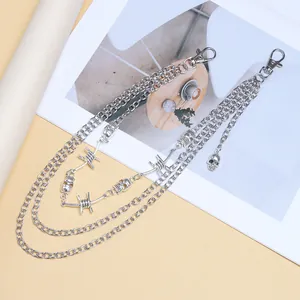 Detail van de drielaagse punk broekketting met schedelhangers en prikkeldraadschakels