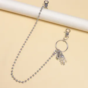 Détail de la chaîne à billes argentée avec pendentif main de squelette gothique