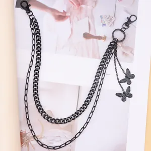 Détail d'une chaîne de pantalon double en métal noir avec pendentifs papillon stylés