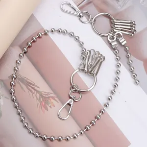 Silver bead chain accessory with lobster clasps and keyrings on a minimalist background