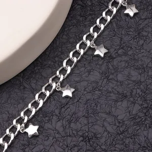 Primer plano de tobillera de cadena gruesa plateada con cinco dijes de estrellas pequeñas