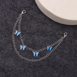 Détail de chaînes de chaussures argentées à double couche avec pendentifs papillons bleus