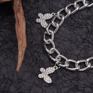 Catena per scarpe argento con ciondoli a farfalla in strass su sfondo nero elegante