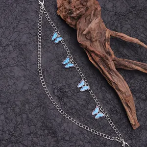 Détail d'une chaîne de chaussure double en métal argenté avec pendentifs papillon bleus