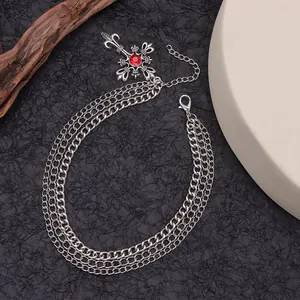 Detalle de cadenas multicapa para zapatos con colgante de cruz y rubí rojo
