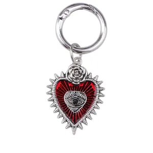 Macro detail of Gothic devil eye heart charm with silver rose and red enamel texture