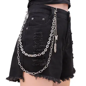 Detail of silver layered trousers chain with butterfly and feather charms on black denim