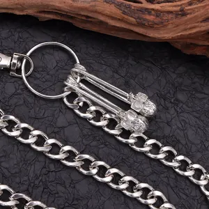 Macro detail of silver punk pant chain featuring gothic skull pendants and lobster clasp