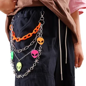 Detail of neon layered pants chain with alien pendants and orange plastic links