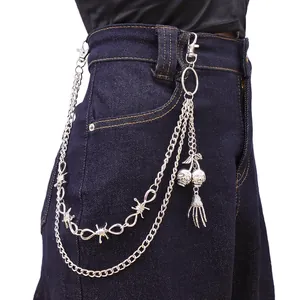 Detail of gothic punk trousers chain with barbed wire links and skull pendants