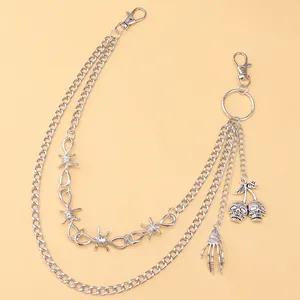 Close-up of gothic silver pants chain with skull hand, cherry skulls and barbed wire details