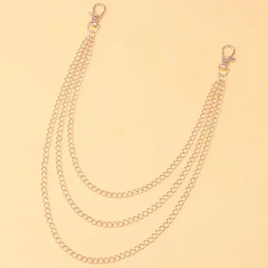 Close-up of triple-layered golden metal pant chains with secure lobster clasps