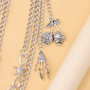 Detailed close-up of gothic skull cherry and skeleton hand charms on a punk metal chain